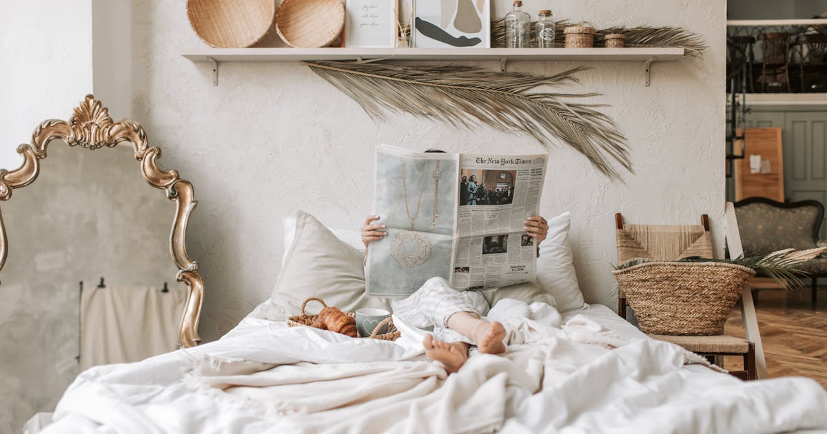 Warm minimal bedroom with a single framed print above the bed, neutral linen tones and soft morning light