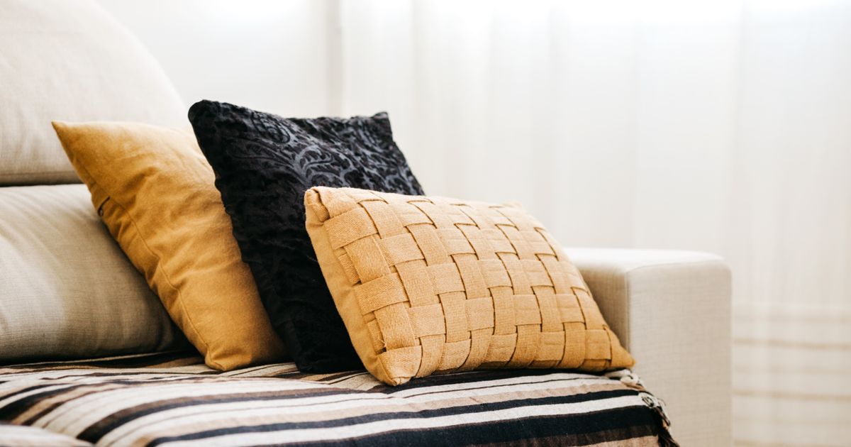 Modern interior design featuring a comfortable sofa with decorative pillows and a striped throw.