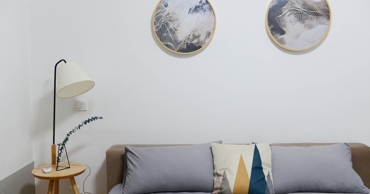 Stylish modern bedroom featuring minimalist decor with abstract wall art and cozy furniture.