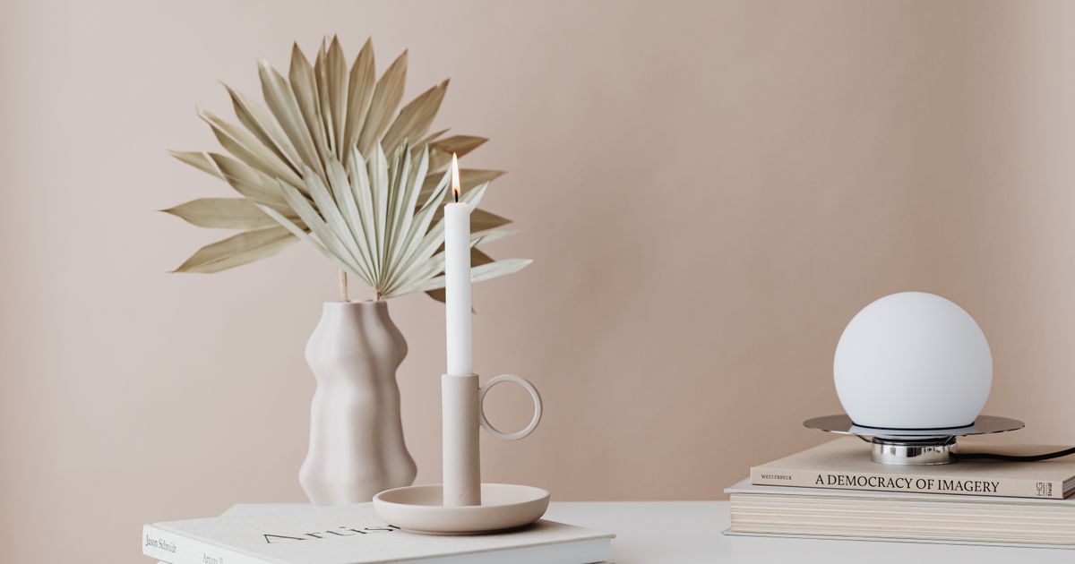 A minimalist setup featuring a candle, books, and modern home decor.
