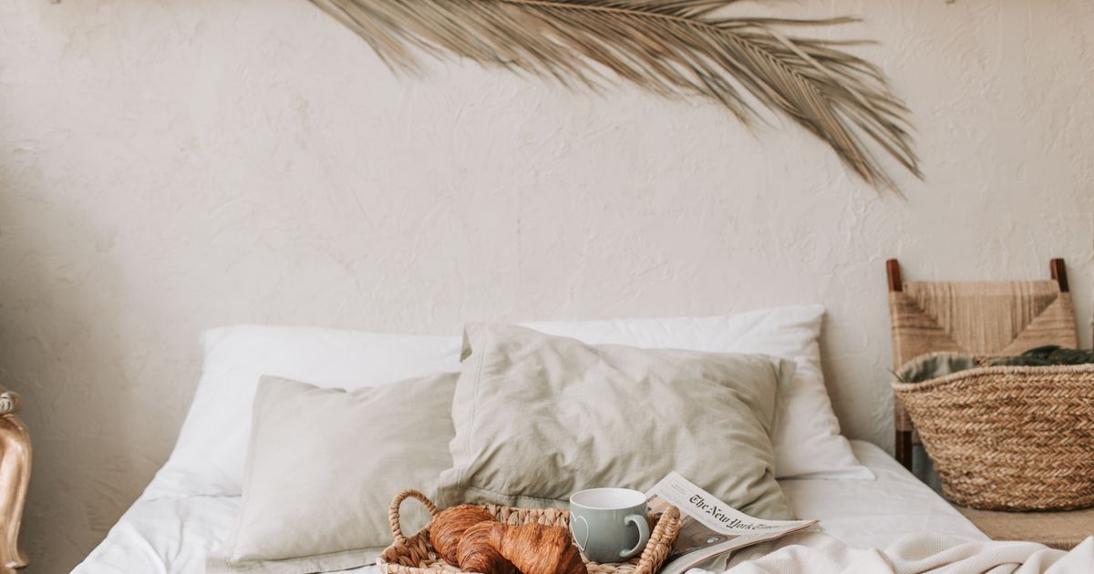Warm and cozy bedroom with a breakfast tray and croissants for a relaxing morning.