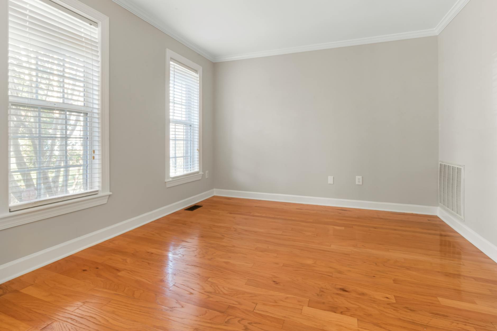 Spacious empty room with natural light and neutral bare walls, representing the quiet in-between after a major life change