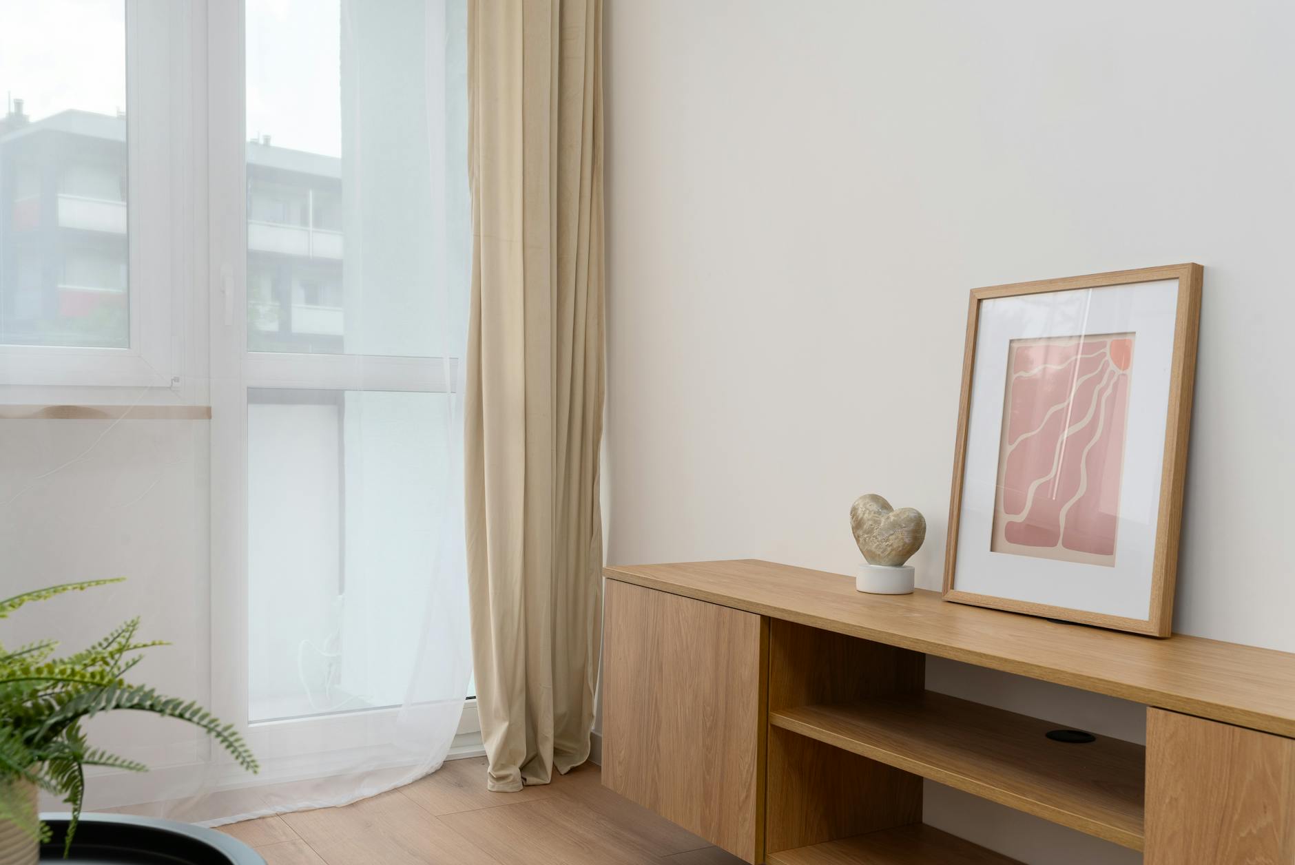 A bright and airy room with framed abstract art and natural light, showing a minimal cohesive wall art arrangement