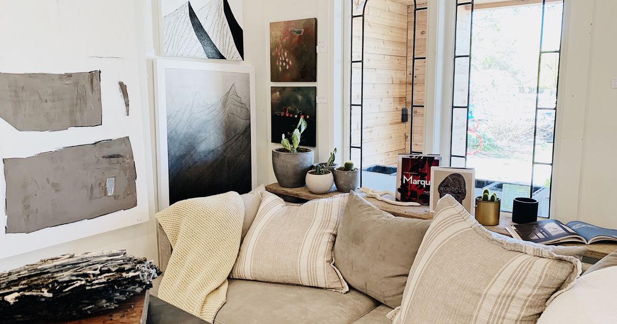 Inviting living room with cozy decor, modern art, and soft lighting for relaxation.