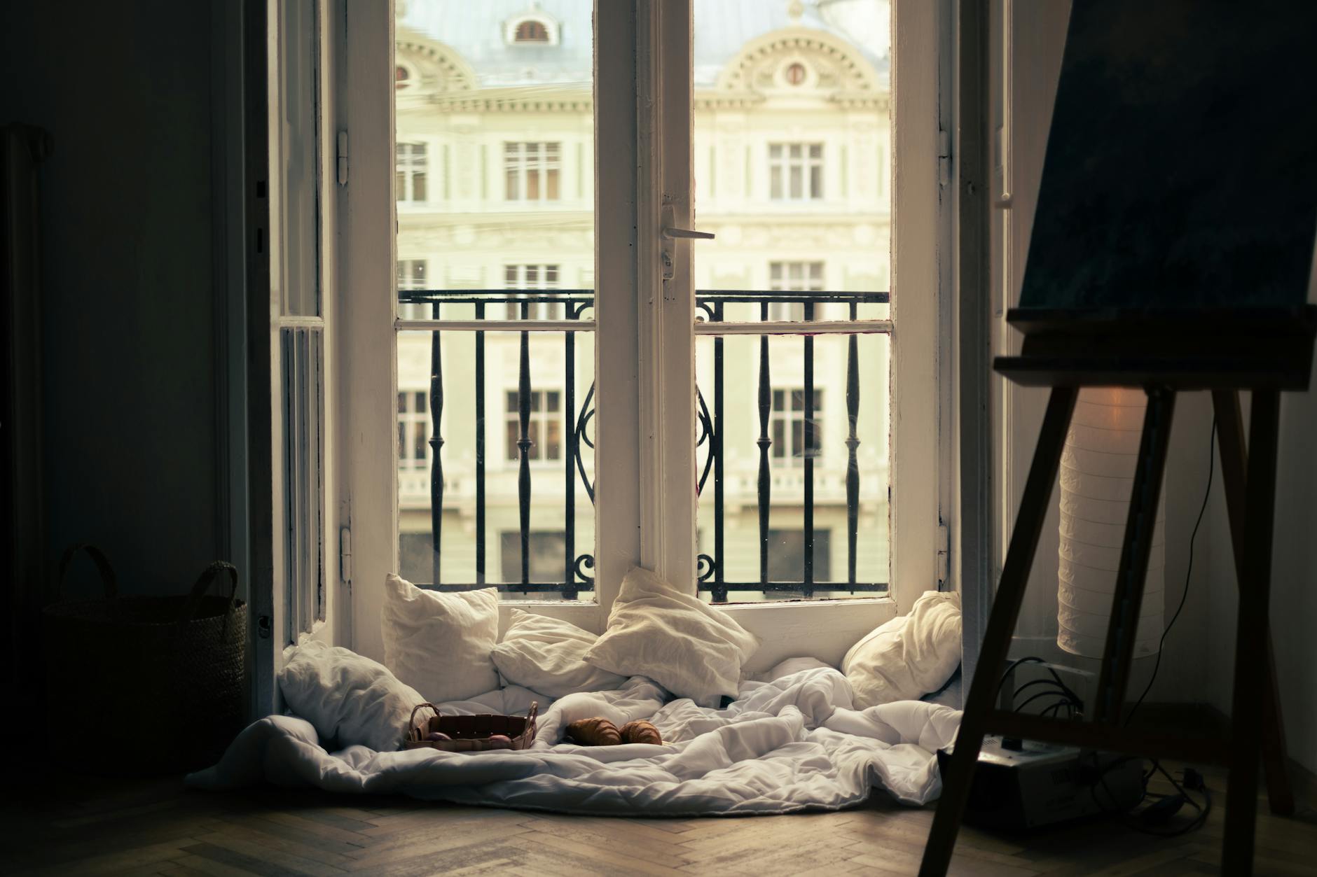 Cozy pillows by a window with soft natural light, creating a quiet and intentional corner in a home