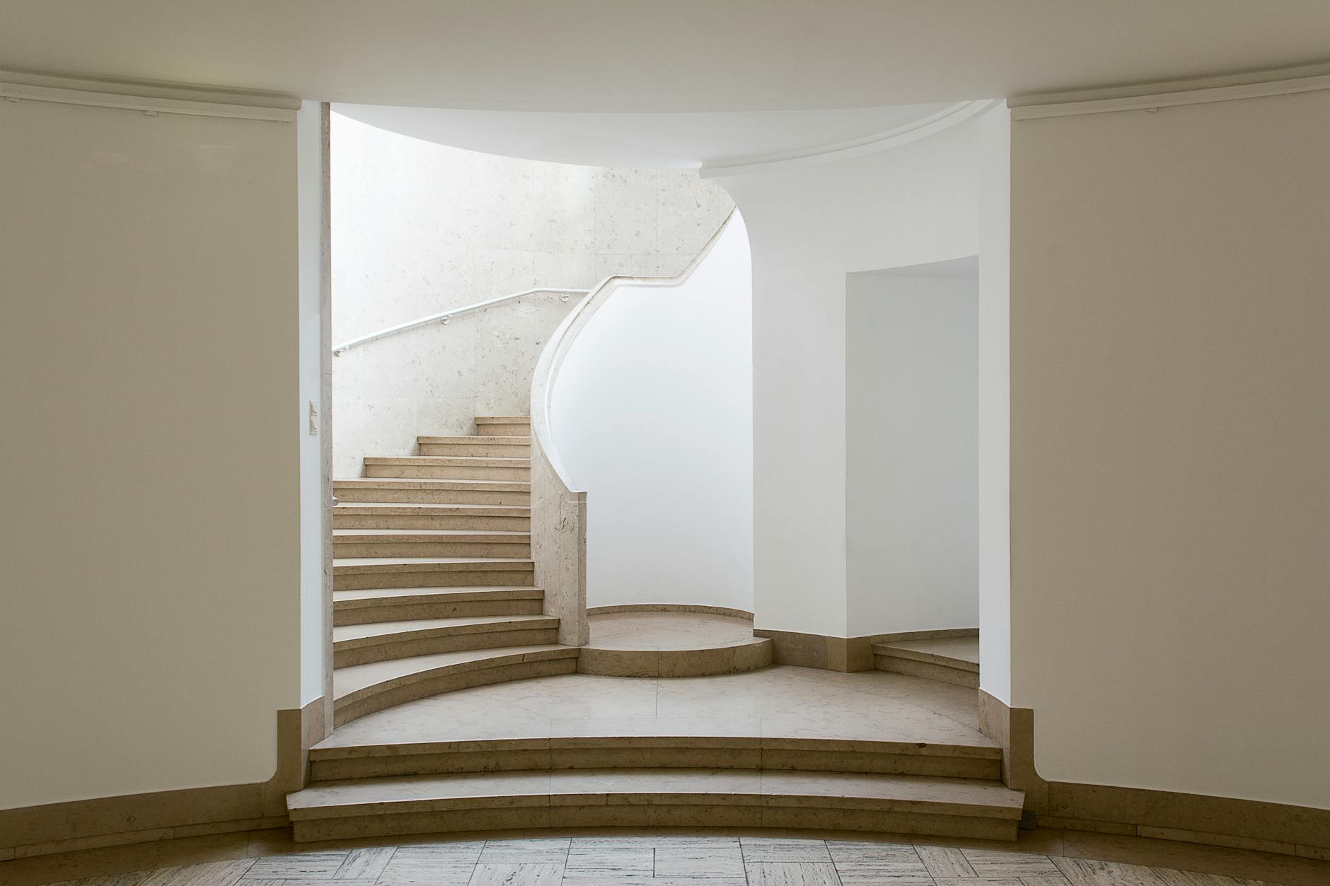 A minimalist curved staircase interior with clean lines and natural light, emphasizing simple elegant design