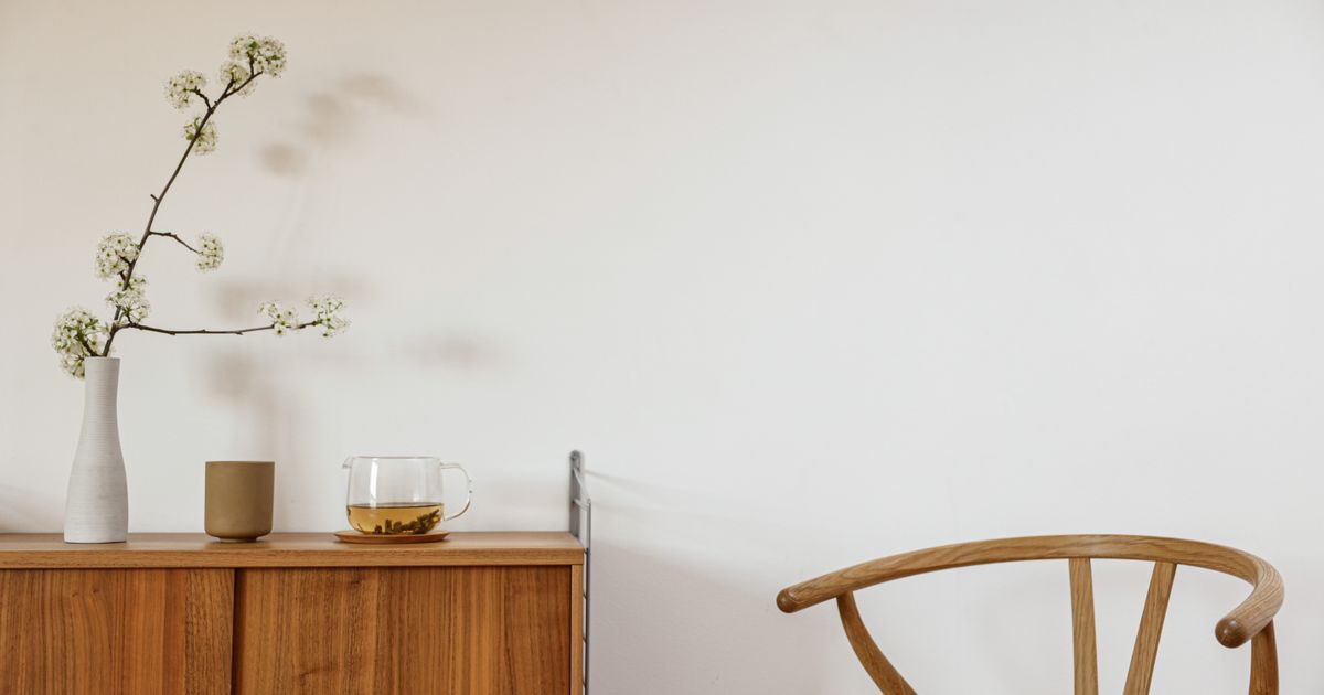 A minimalist room featuring a wooden chair and table, perfect for modern home decor.